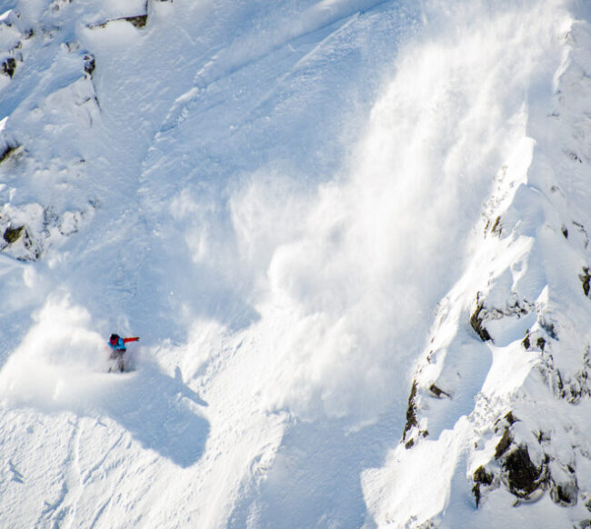 Sluff snowfall caused by a Freeride boarder on a steep slope over 45 degrees