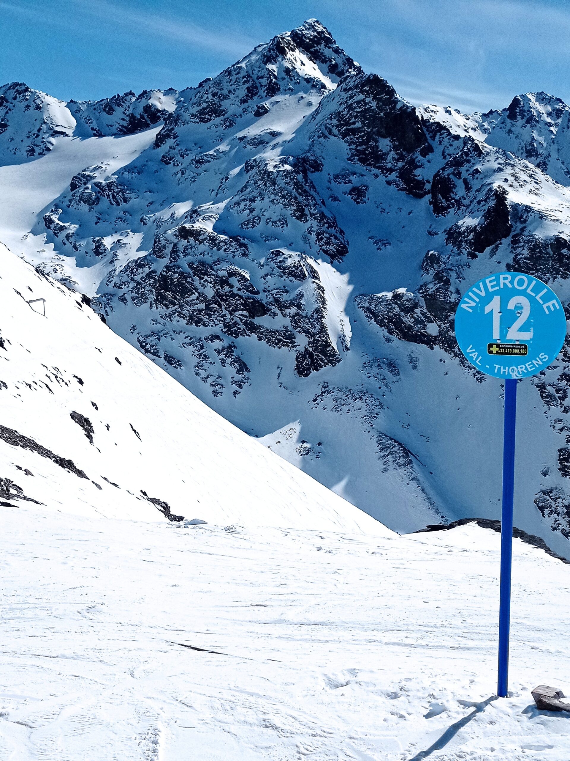 Cross over the Col onto the southern side at the No.12 piste marker just a few metres from the top of the Funitel. The Pointe du Bouchet and the Glacier du Bouchet can be seen in the background.